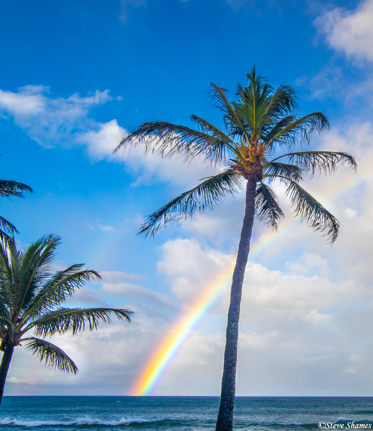 Rainbow rising out of the ocean off the shore of Lahaina, Maui.