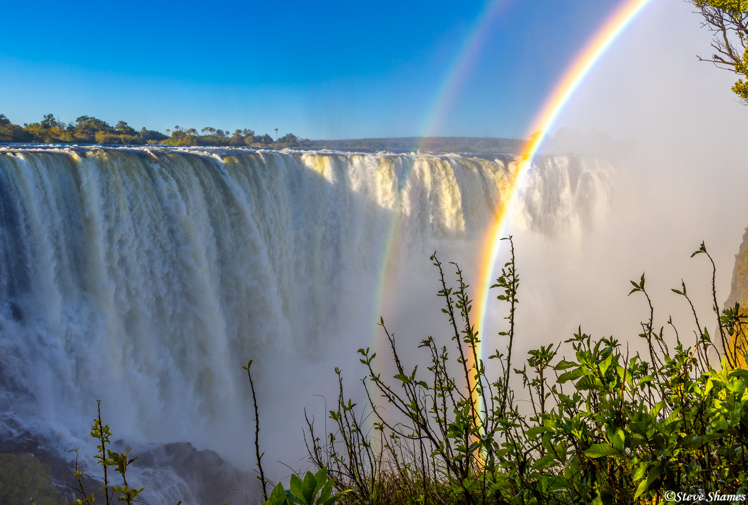 The spectacular Victoria Falls, with a double rainbow over it.